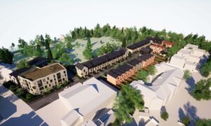 Digital visualisation looking down on the rooftops of the new homes. Facing the street is a light brick coloured block of apartments four-storeys high, behind which are a series of pitched rooved three-storey houses. Tree and open land are shown in the background.
